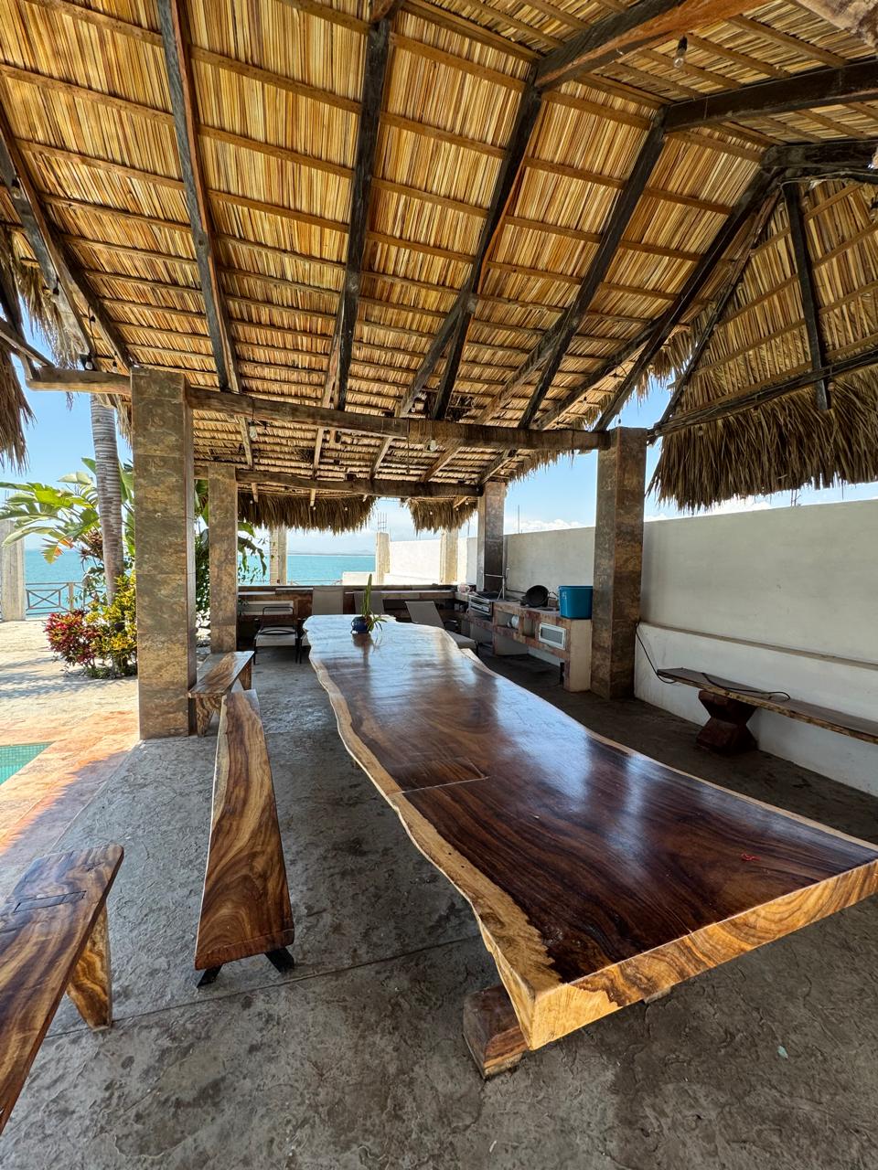 Palapa con mesa de madera y vista al mar